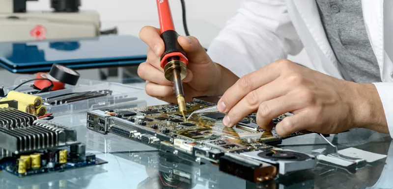 Engineer soldering components on a circuit board