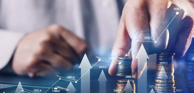 Stacks of coins beside a rising growth chart